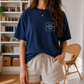 Model wearing oversized dark blue coloring book lover t-shirt, front view